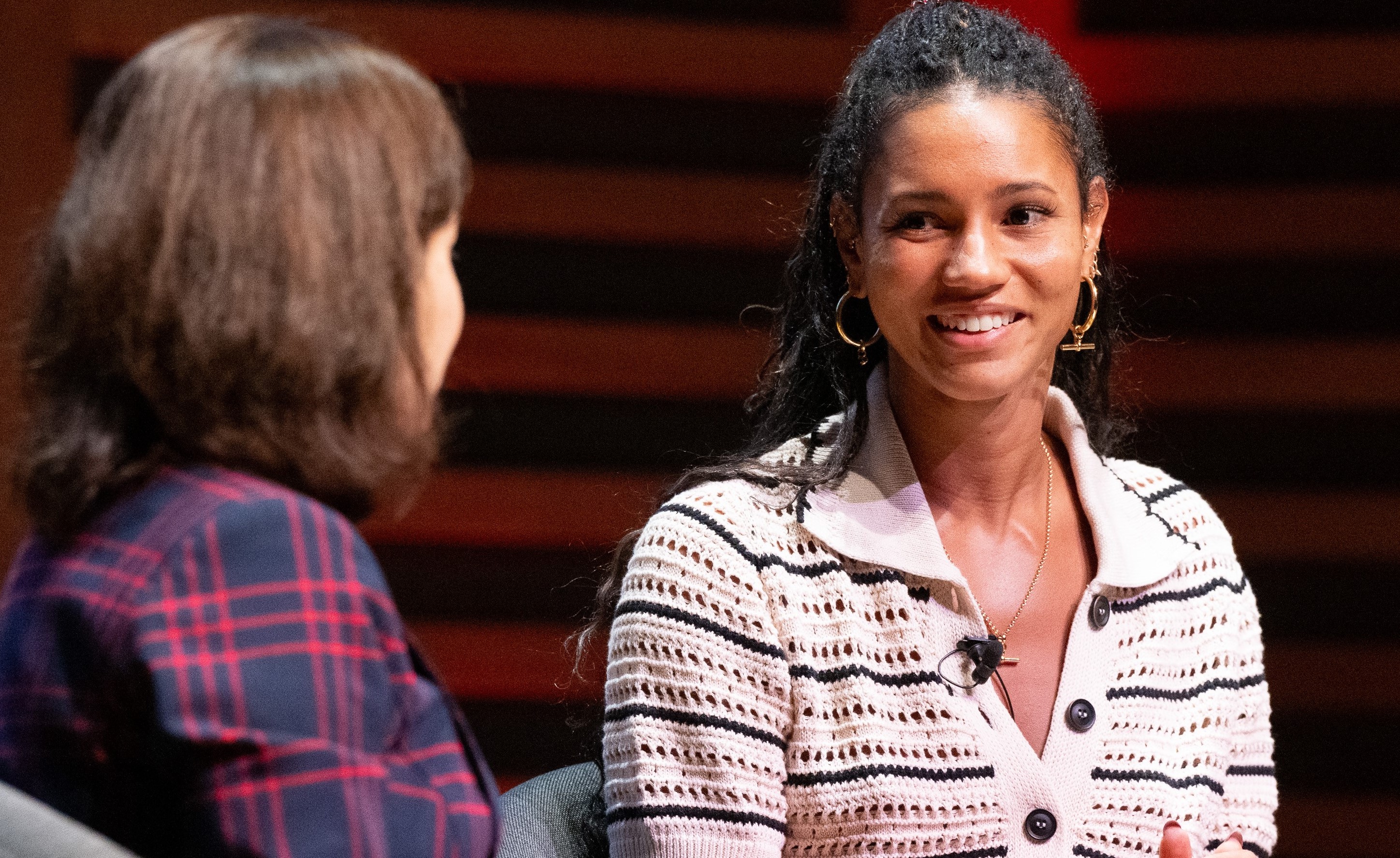 Vice Chancellor Professor Deborah Prentice in a purple check suit and alumna Vick Hope in a white striped shirt, in conversation