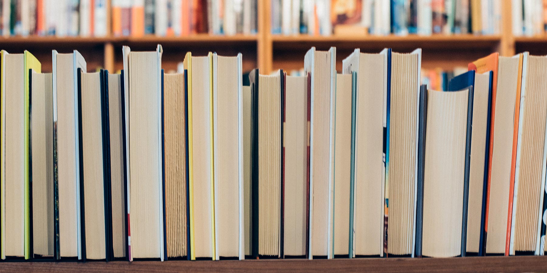 Close up of a bookshelf with only the fore-edges visible