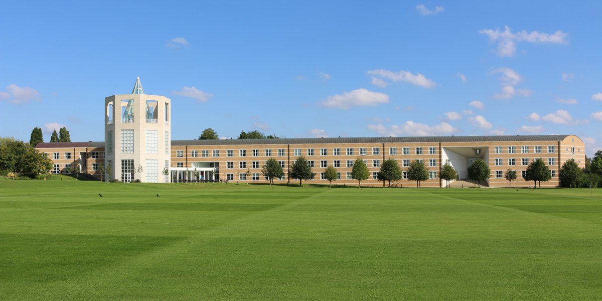 Long shot of the Moller Institutre across a very tidy green
