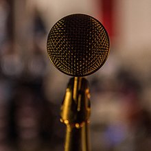 A microphone on a stand in a dimly lit room