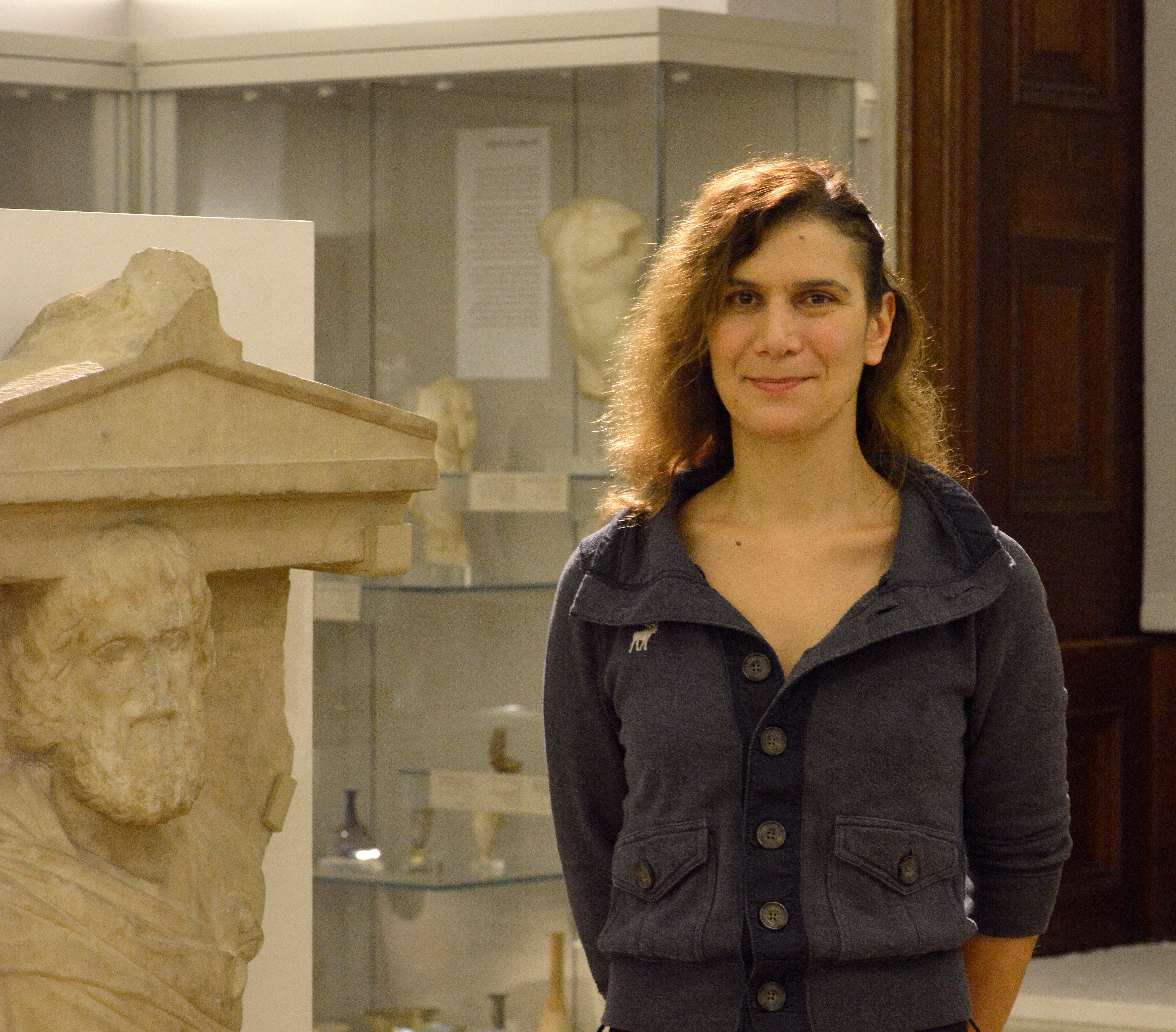 Anastasia Christophilopoulou in the Fitzwilliam Museum beside a statue.