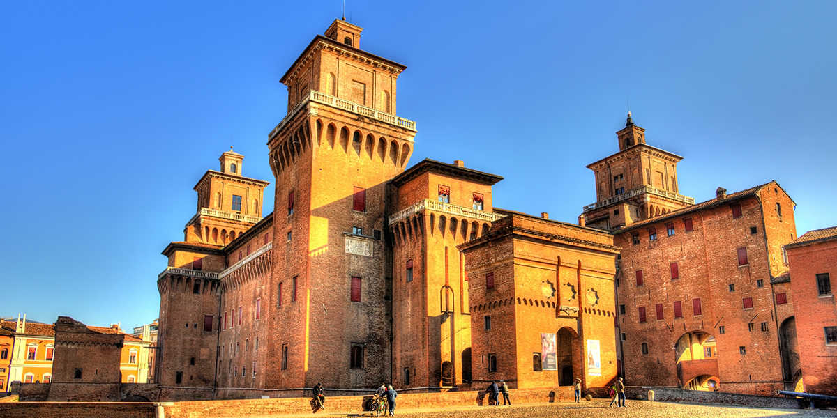 Ferrara Castle basking in golden sunshine with clear blue sky in the background