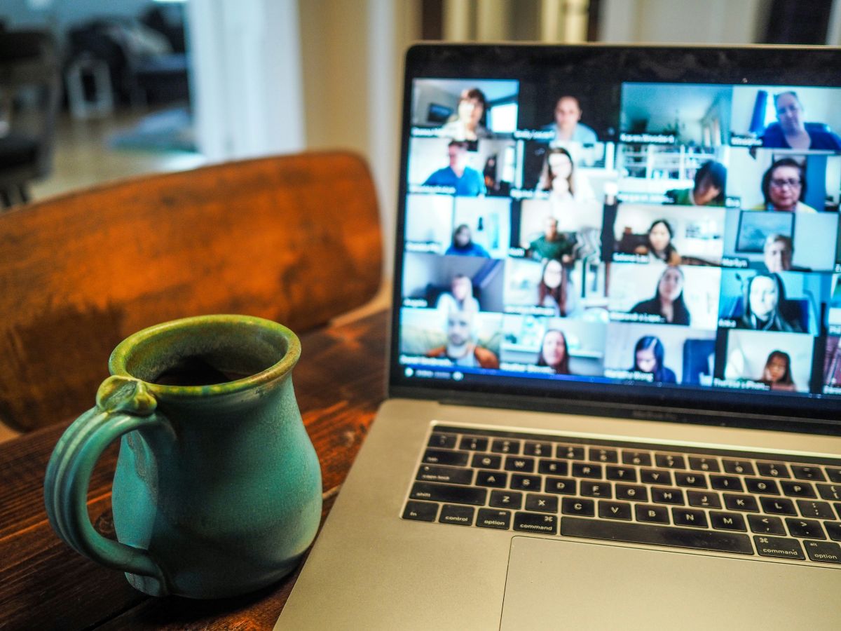 A laptop and cup of coffee sit on a desk