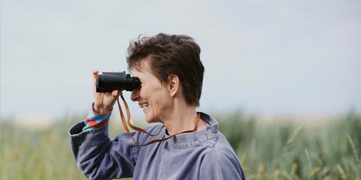 Professor Carol Brayne holding binoculars