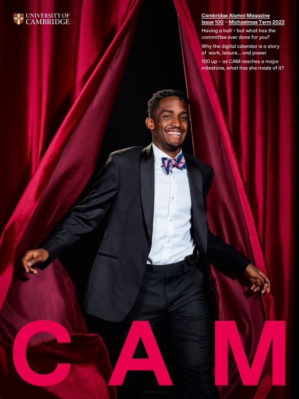 Cover of CAM 100 showing a person emerging from red curtains