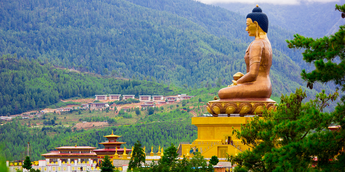 Dordemna golden statue, looking out over the Bhutan kingdom of white buildings and bright green trees