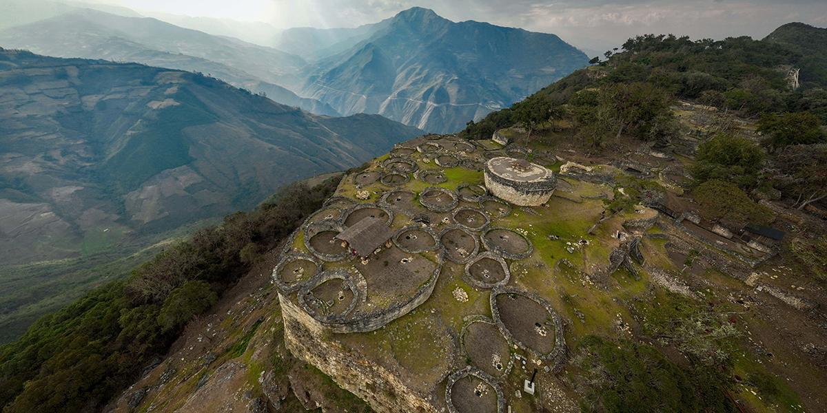 Aerial view of Kuelap ruins with circular stone structures on a mountain ridge