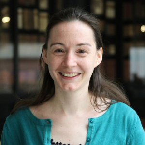 portrait photograph of Amelie Roper against a dark background wearing a blue top