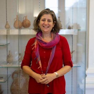 photograph of Susanna Pancaldo standing in front of a museum glass display cabinet