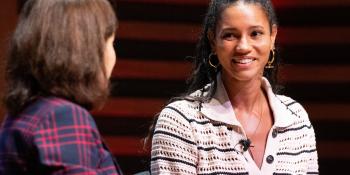 Vice Chancellor Professor Deborah Prentice in a purple check suit and alumna Vick Hope in a white striped shirt, in conversation