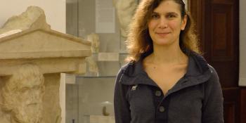 Anastasia Christophilopoulou in the Fitzwilliam Museum beside a statue.