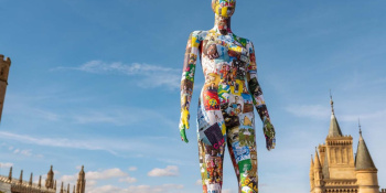 The CAM mannequin stands against a blue sky.