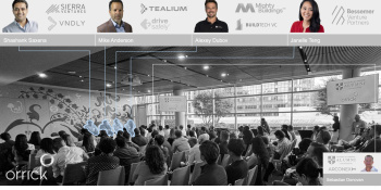 Photograph of the event highlighting the speakers in the crowd