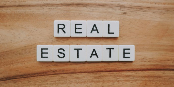 The words 'Real Estate' spelt out with letter tiles