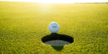 A golf ball on the edge of the hole