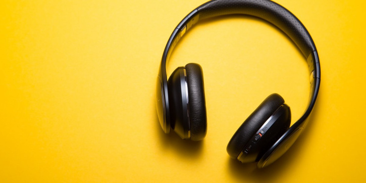 Photo of a pair of overear headphone on a yellow background.