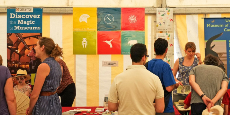 People gathered and attending stales within a large tent