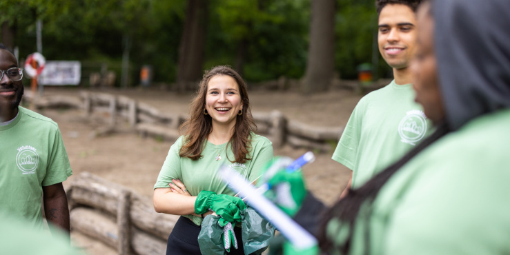photograph depicting volunteers in a woodland setting talking and laughing