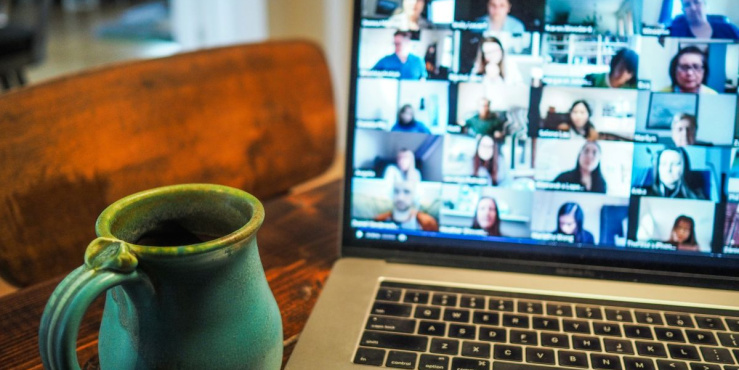 A laptop and cup of coffee sit on a desk