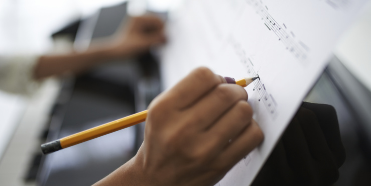 Music being written in pencil on sheet music paper