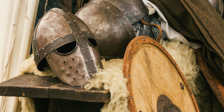 Medieval helmet and shield rest on a table