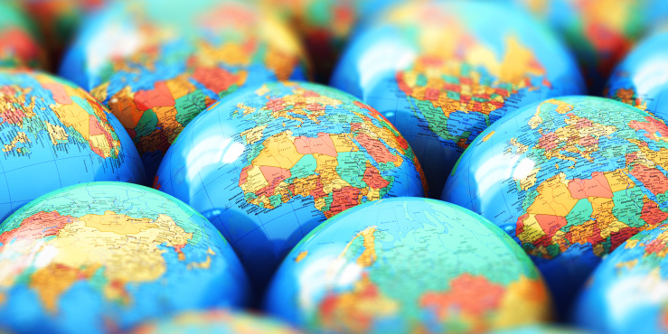 A collection of globes sit together showing different continents.