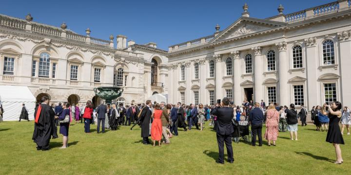 photograph of a group of people attending graduation day in bright sunshine and infront of the Senate House Cambridge