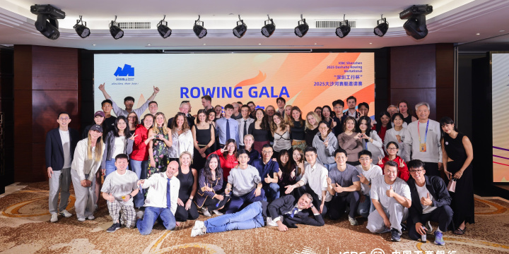 Members of the alumni groups gather for a group photo, they are smiling and showing peace hand gestures