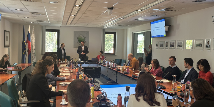 Group of alumni around a conference table watching a presentation