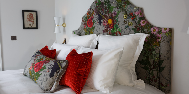 Double room, flower head board, red and white pillows