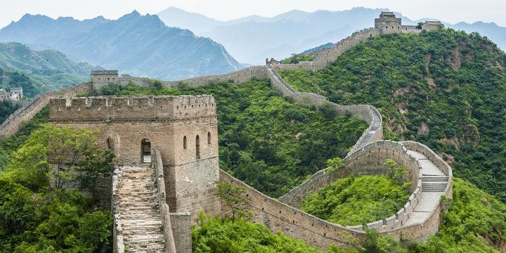 Great Wall of China snaking through the green mountains as far as the eye can see