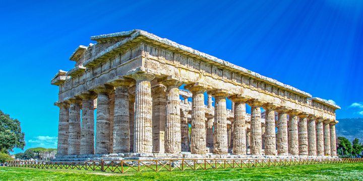 Perspective photo with Italian ribbed columns with lush green grass and beautiful clear blue sky