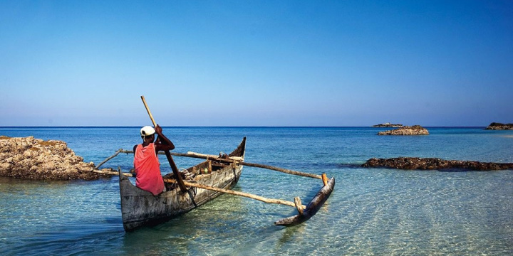 Tsaeabanjina fisherman in a boat sailing out into the crystal blue water
