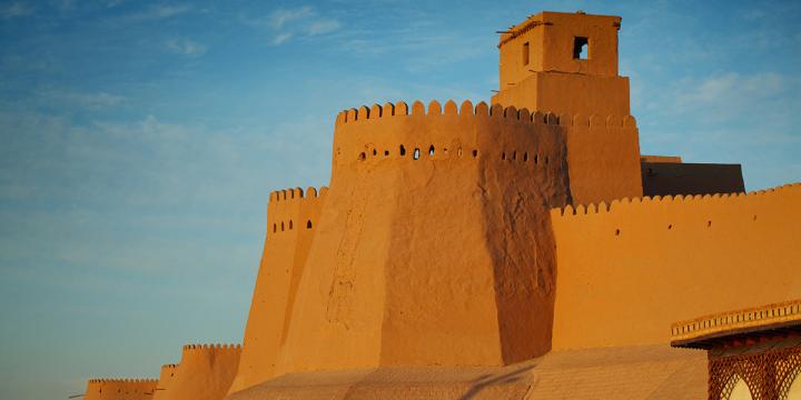 Orange walls of Khiva, with contrasting blue sky background