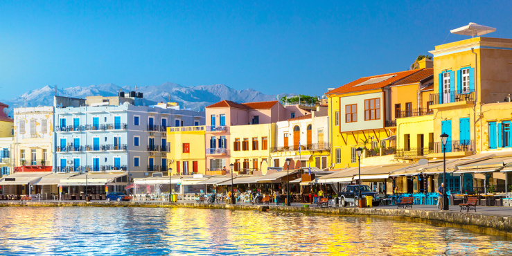 Row of colourful buildings along a lake sore, with a clear blue sky