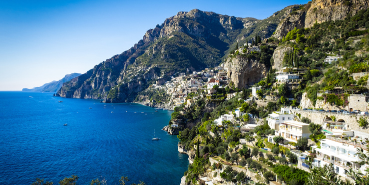 White buildings in the hillside looking over crystal clear blue water