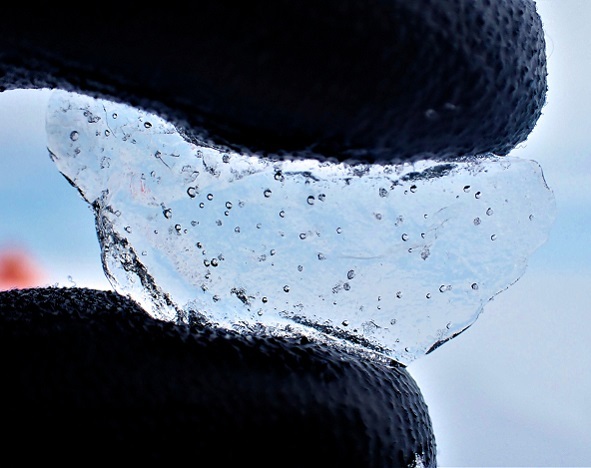 An ice chip held between gloved fingers