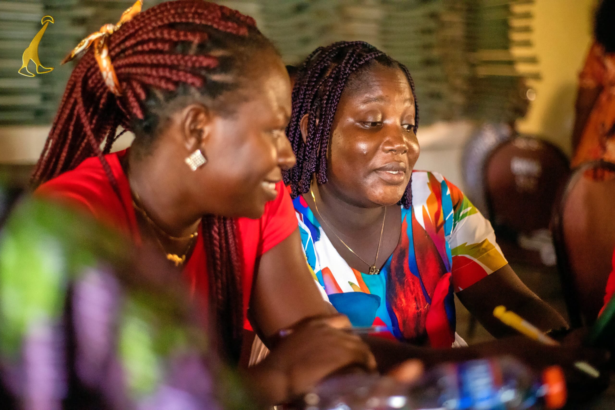 Two African ladies sit together wearing bright patterned clothing. Click the link below to visit the Education and Aspirations Hub website.