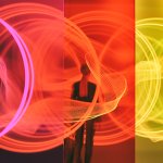 Woman standing in front of colourful screens