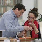 two people working on conservation of a book