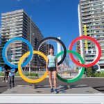 Student athlete in front of the Olympic rings