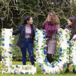 'Lucy' spelt out in flowers with members of the Committee