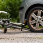 Cycling helmet lying on the floor by a crashed bicycle