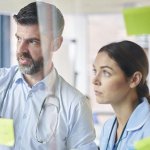 Medical team in a training workshop looking at notes on a wall