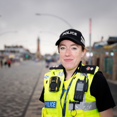 Portrait photograph of a woman in police uniform out on the streets of a town