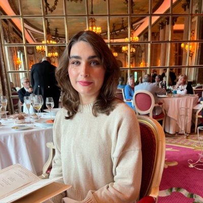 Myrial sitting in a restaurant looking to the camera