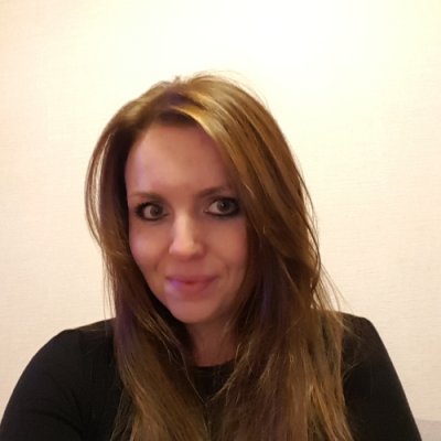 portrait photo graph of a woman with dark hair against a cream backdrop