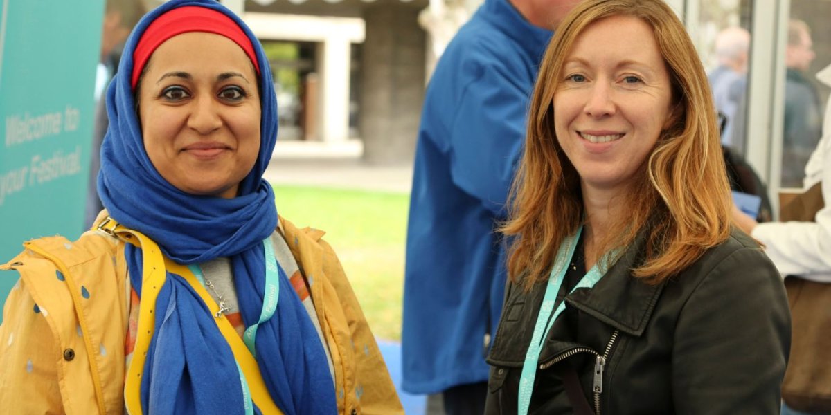 Two women smile to the camera.