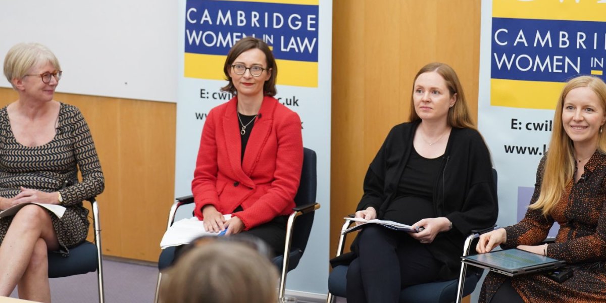 Four women are seated as part of a panel discussion.