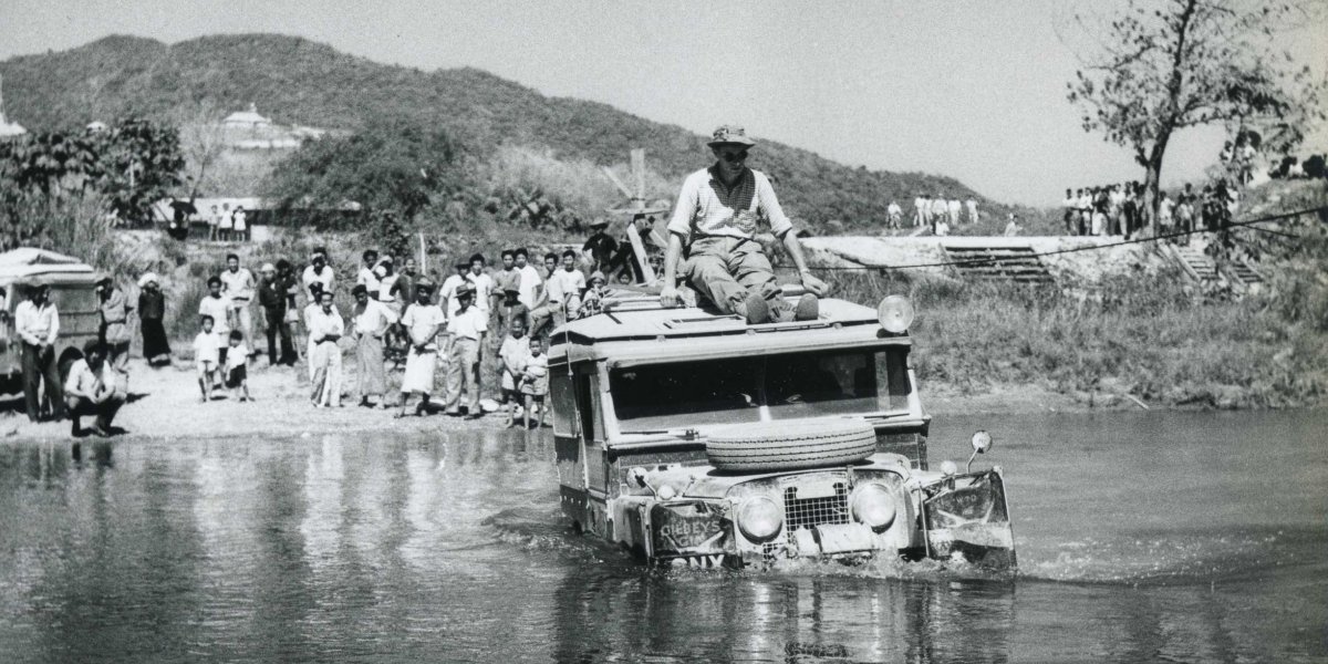 Photo from the first expedition: Tim Slessor sits on top of a landrover fording the Mesai River, Burma (Myanmar)